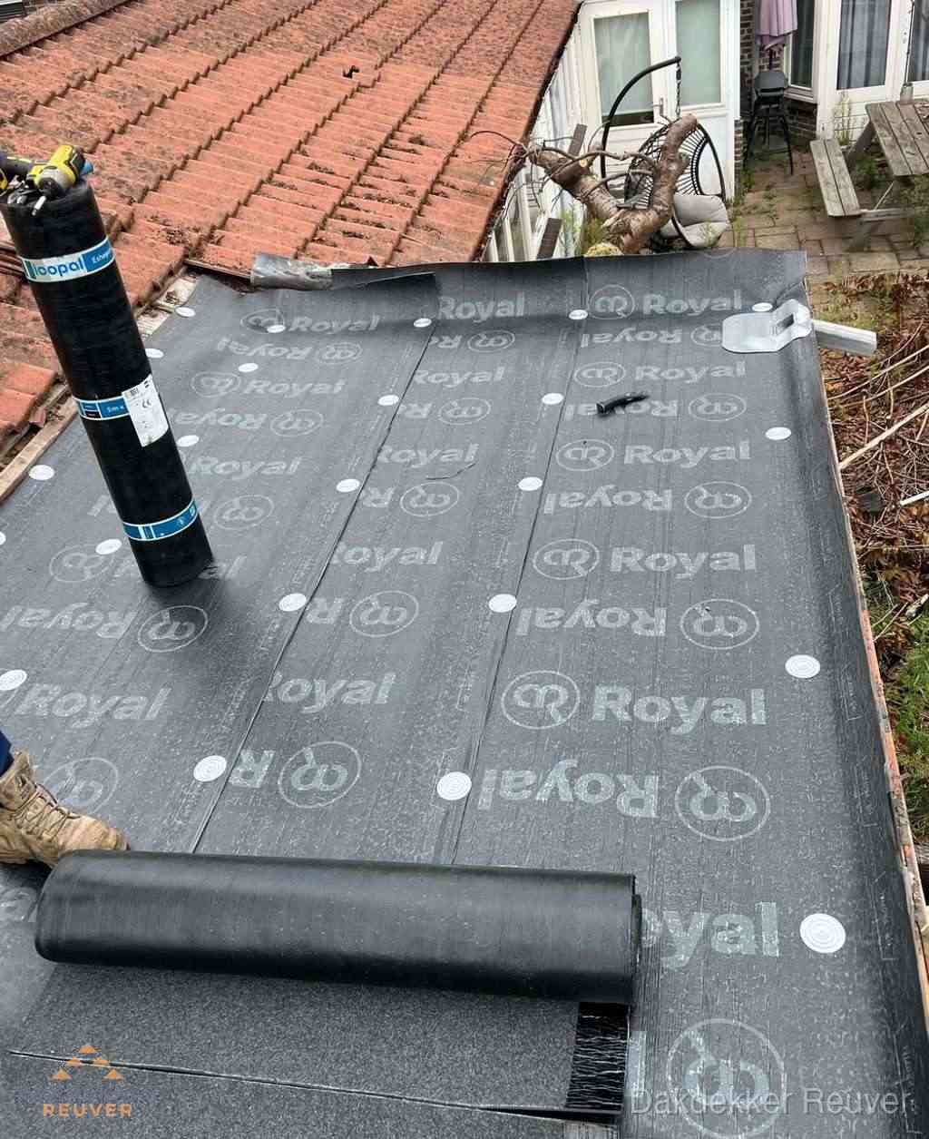 Plat dak met nieuwe bitumen dakbedekking en brandgereedschap in Reuver