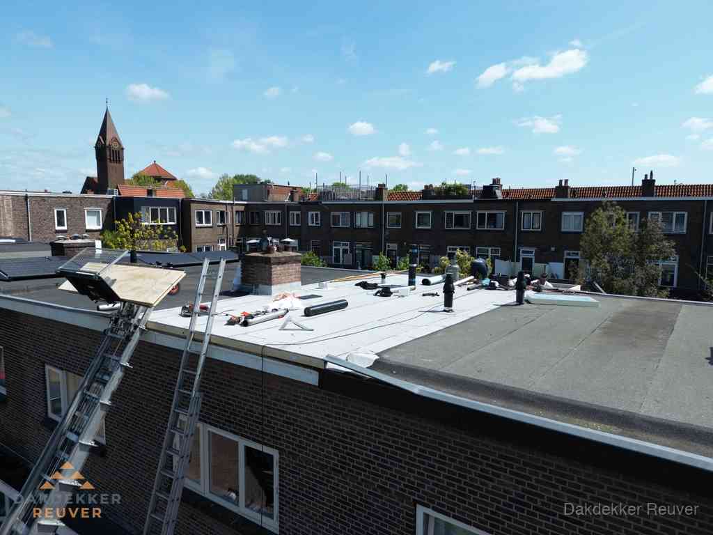 Dakdekkers aan het werk op plat dak in Reuver