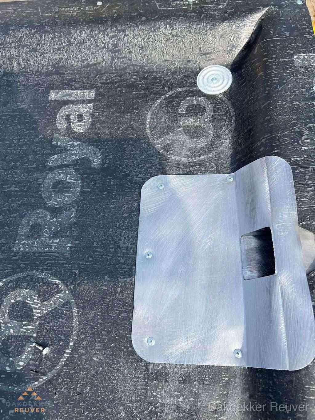 Dakdoorvoer met metalen afvoerplaat op bitumen dak in Reuver