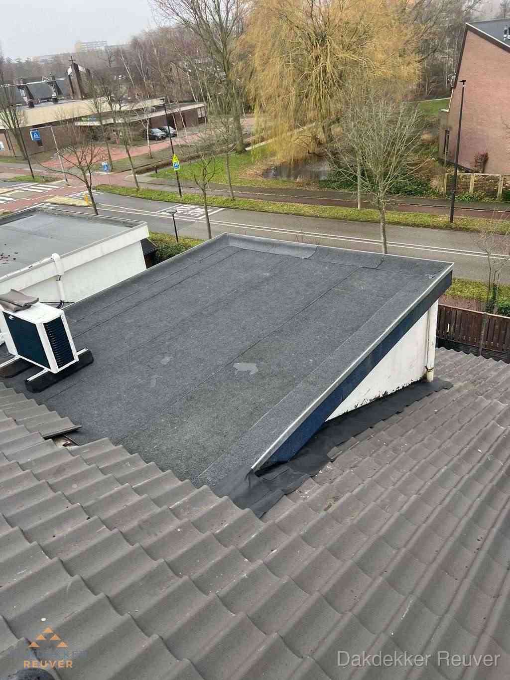 Plat dak met bitumen dakbedekking naast schuin pannendak in Reuver