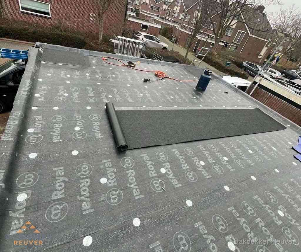 Dakdekker aan het werk met gasbrander op plat bitumen dak in Reuver