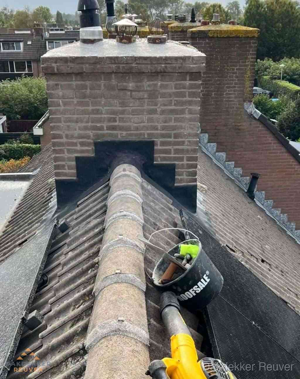 Dakdekker repareert bitumen dakleer bij dakdoorvoer in Reuver
